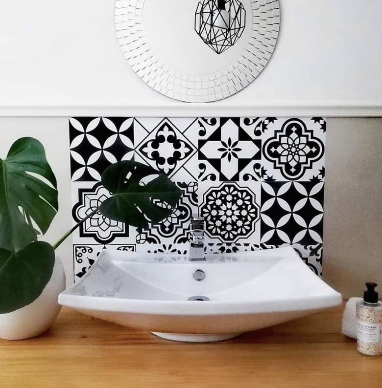 small bathroom backsplash ideas with black and white wall tiles and circle mirror