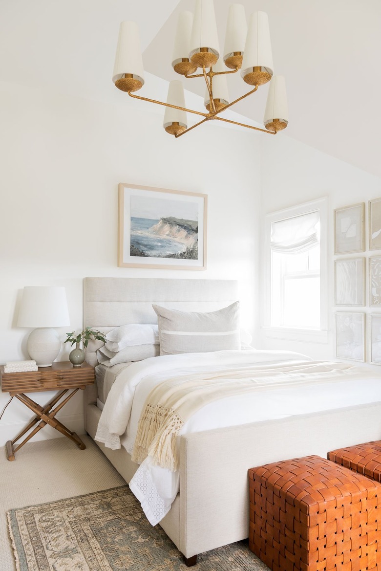 Small bedroom decorating idea in white space with brass chandelier and upholstered bed