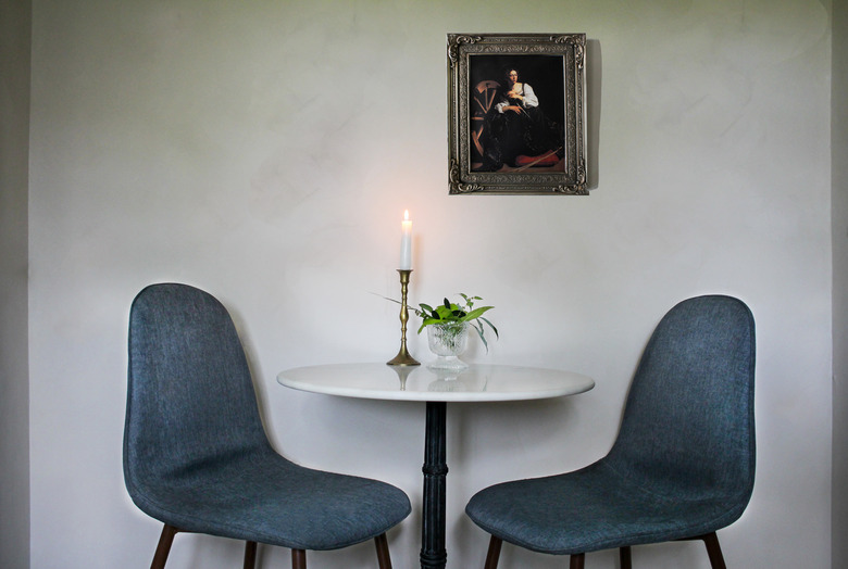 small dining room area with green chairs and a candle.