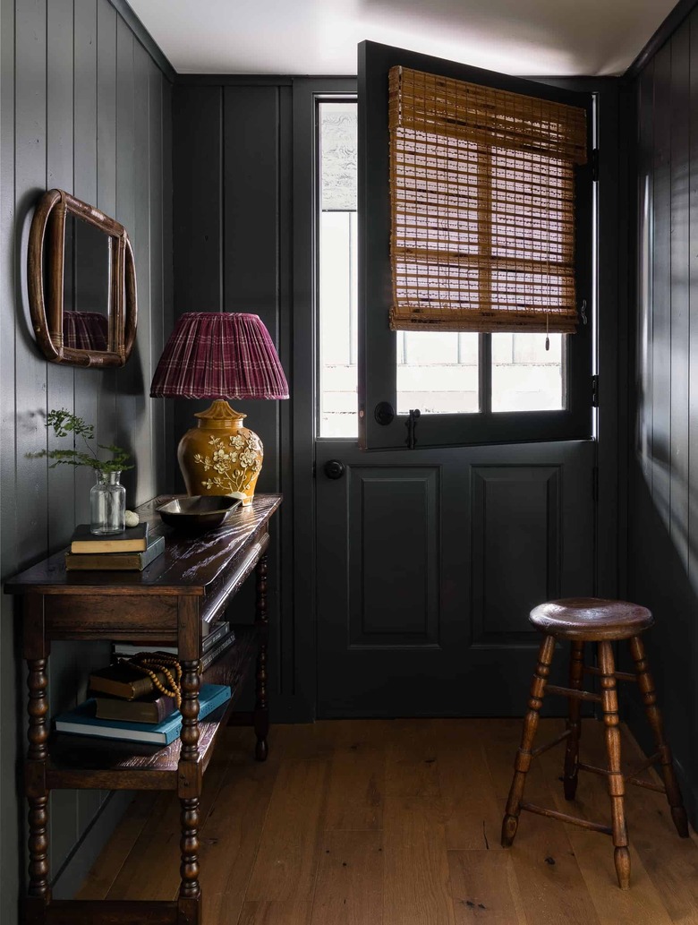 Small entryway with dark paint designed by Heidi Caillier Design