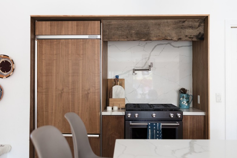 Kitchen with wood cabinets, and a marble or granite backsplash.