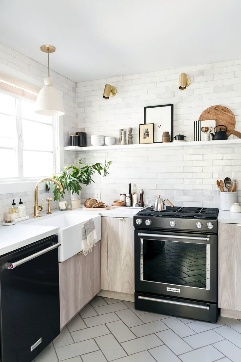 Modern farmhouse kitchen with black range, dishwasher, light wood cabinets, subway tiles, open shelf