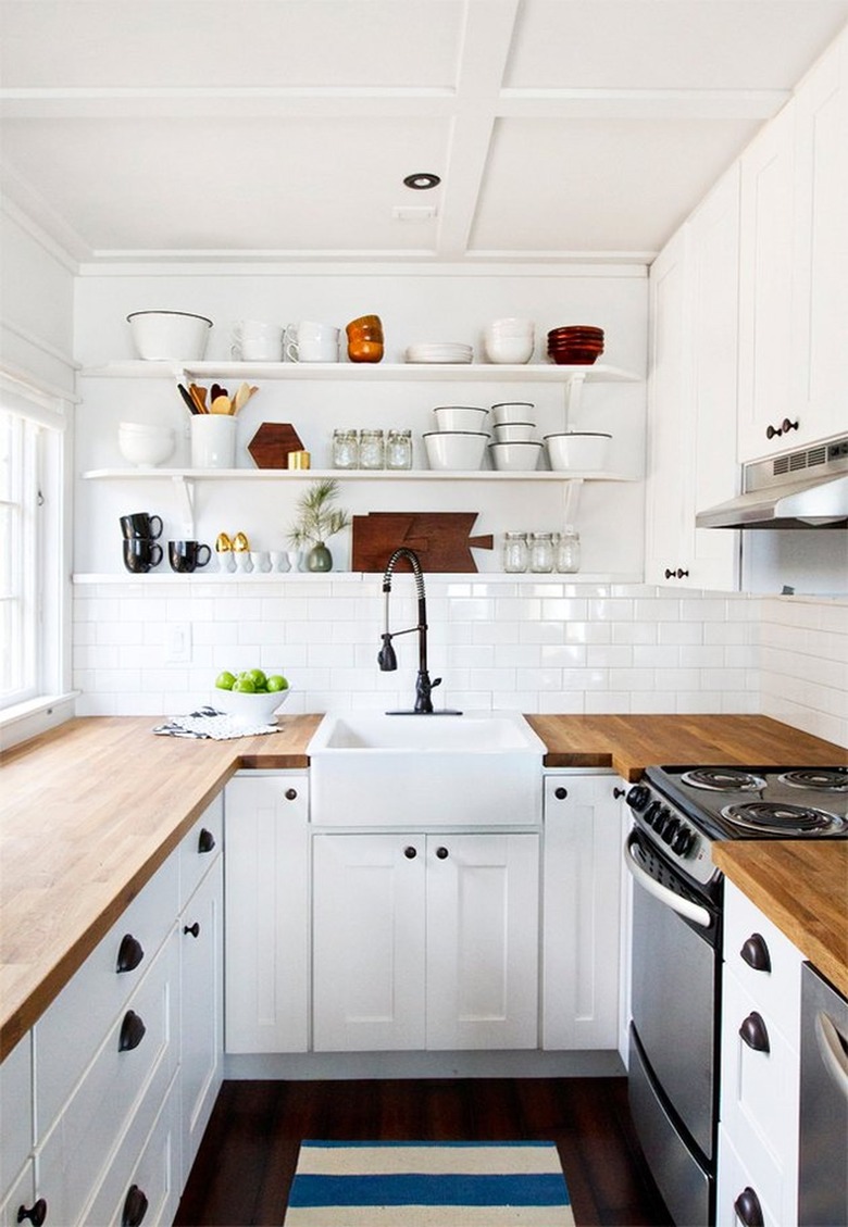 White kitchen with black floors, subway tile.