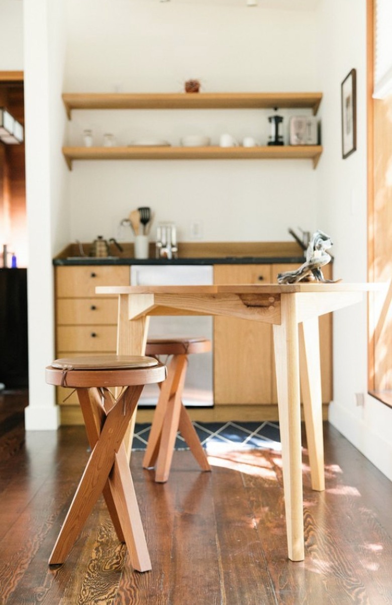 Small kitchen with dining table and wood cabinets.