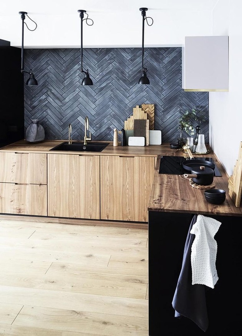 Kitchen with black tile backsplash, wood cabinets.