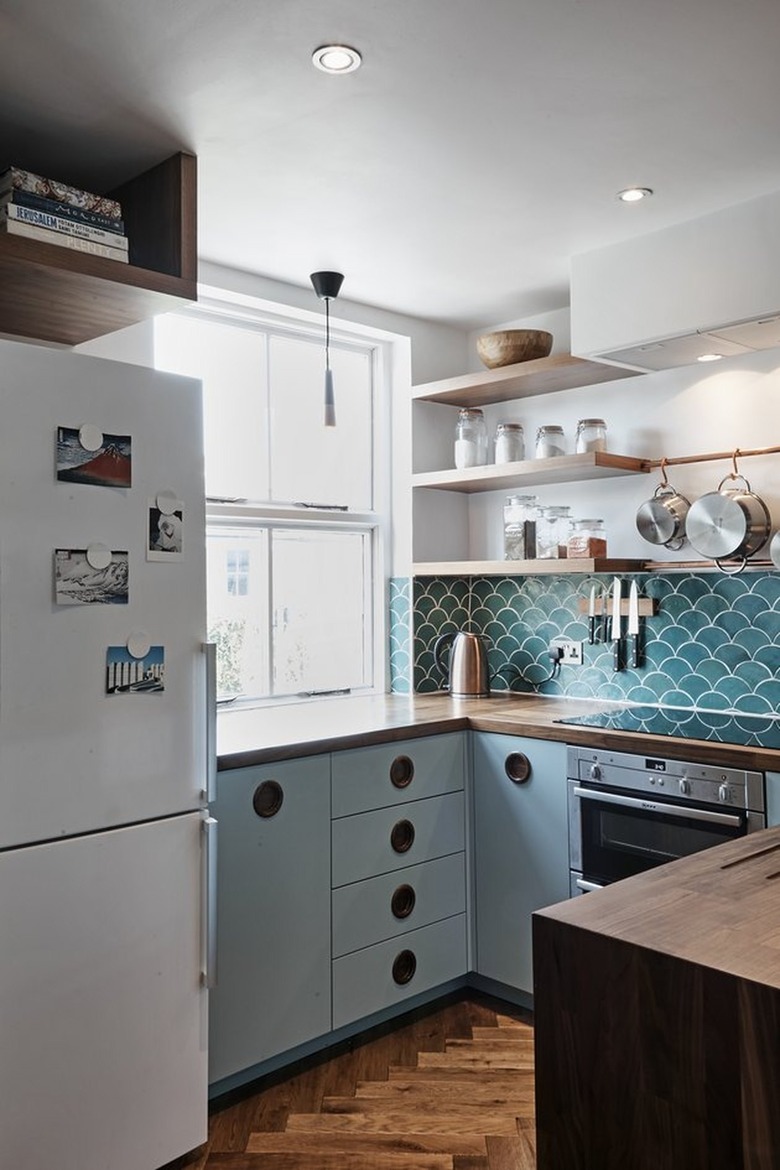 Kitchen with blue cabinets and backsplash, open shelves.