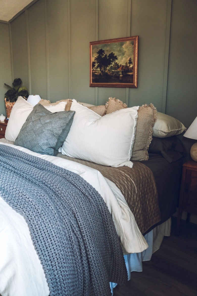 small green bedroom with vintage wall art