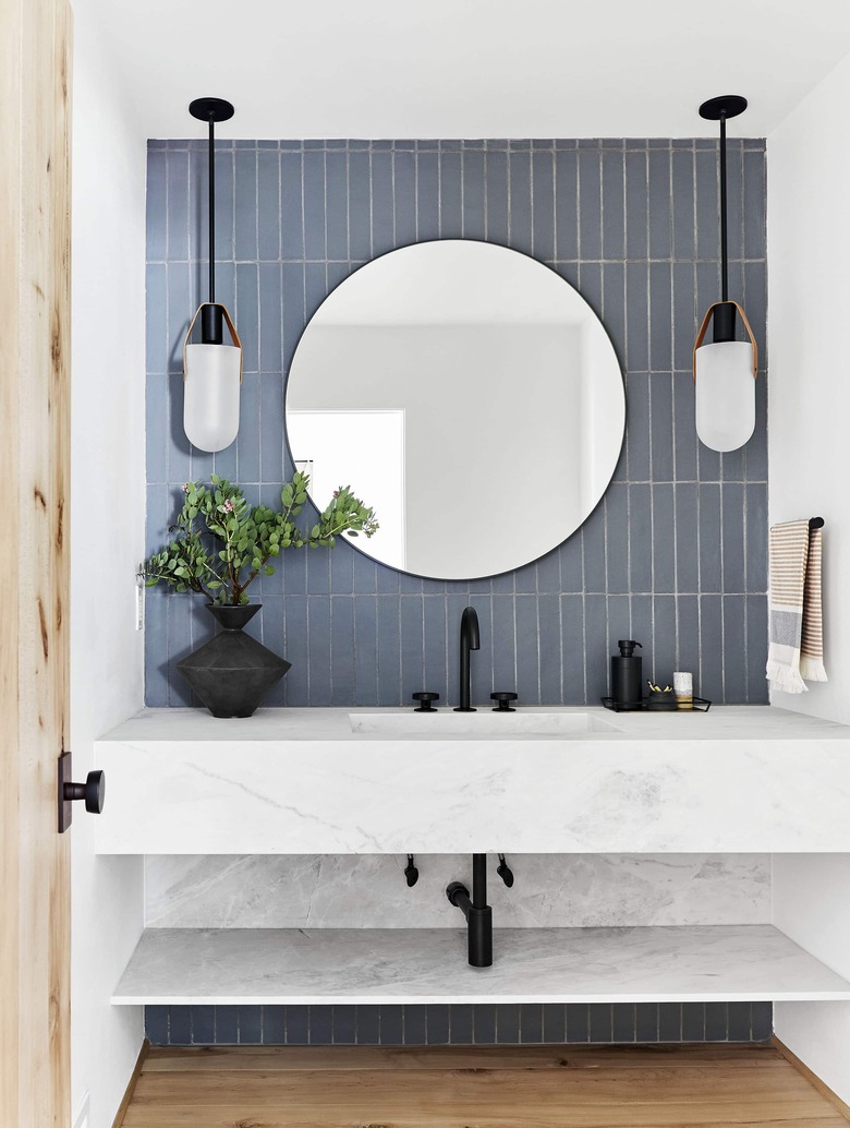 small midcentury modern bathroom with blue backsplash and modern light fixtures