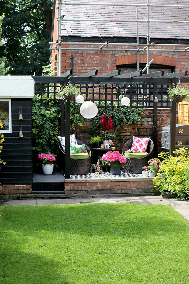 Colorful small patio ideas with paper lanterns, bright throw pillows, and flowers