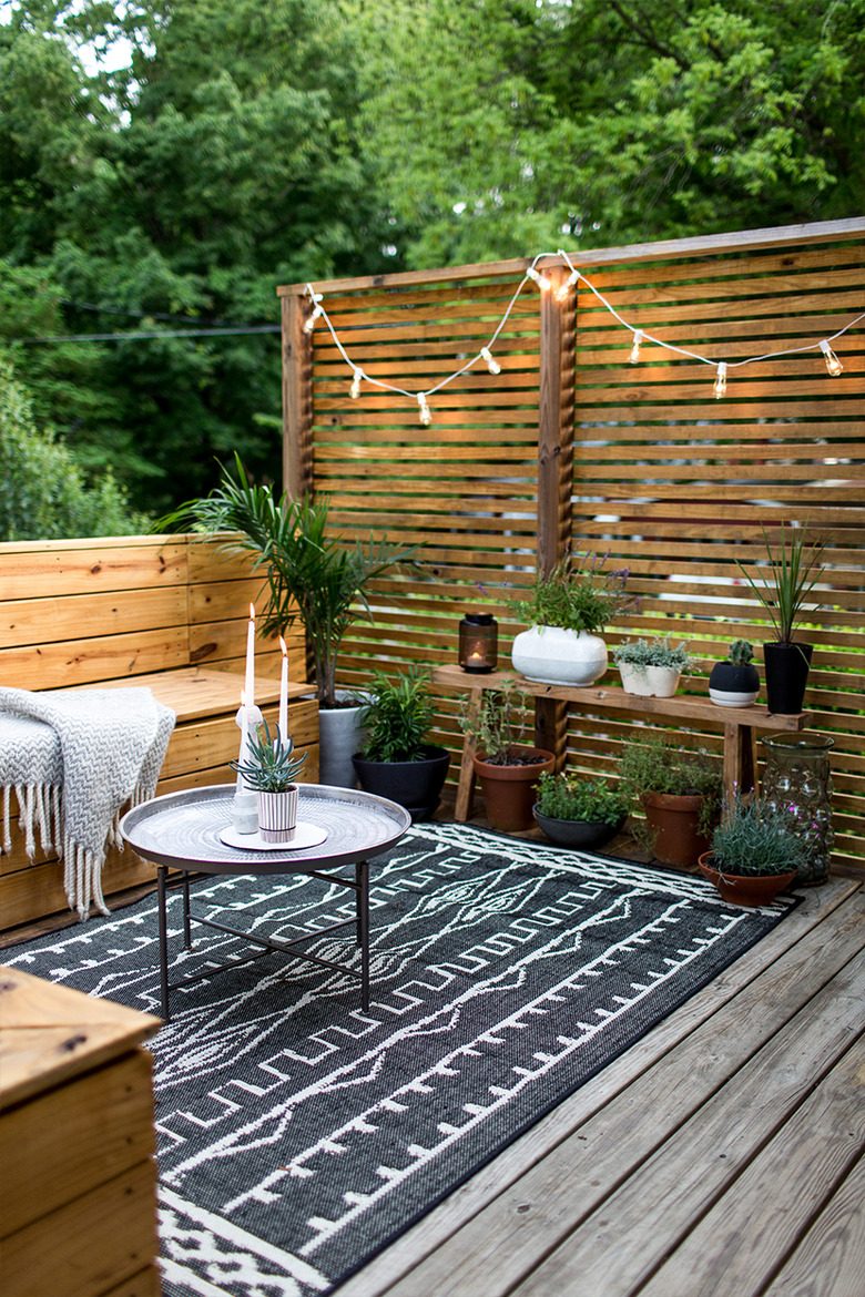 outdoor patio on deck with black and white rug and string lights