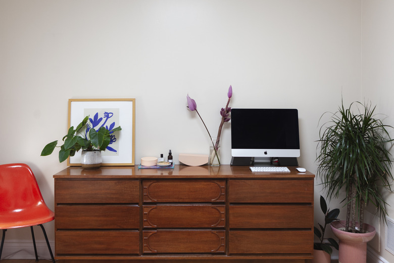 dresser with framed art and computer monitor