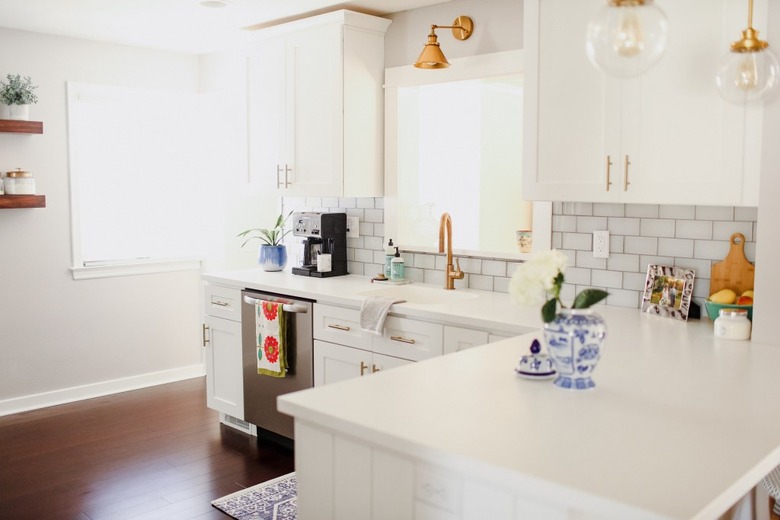 White and brass modern kitchen with solid surface countertops