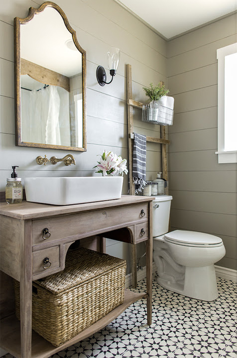 vessel bathroom sink on rustic wood vanity with shiplap walls and patterned floor tile