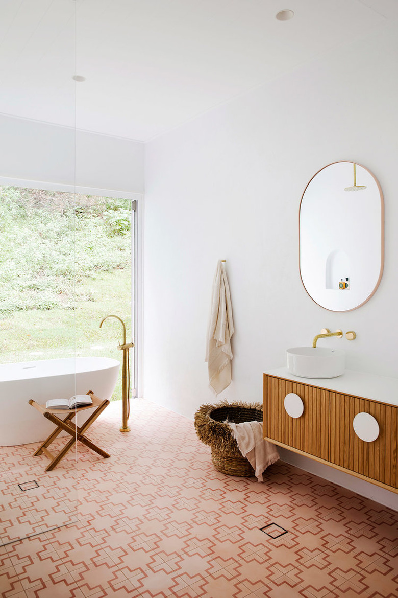 Vessel bathroom sink on floating vanity with wall-mounted faucet and patterned floor tile