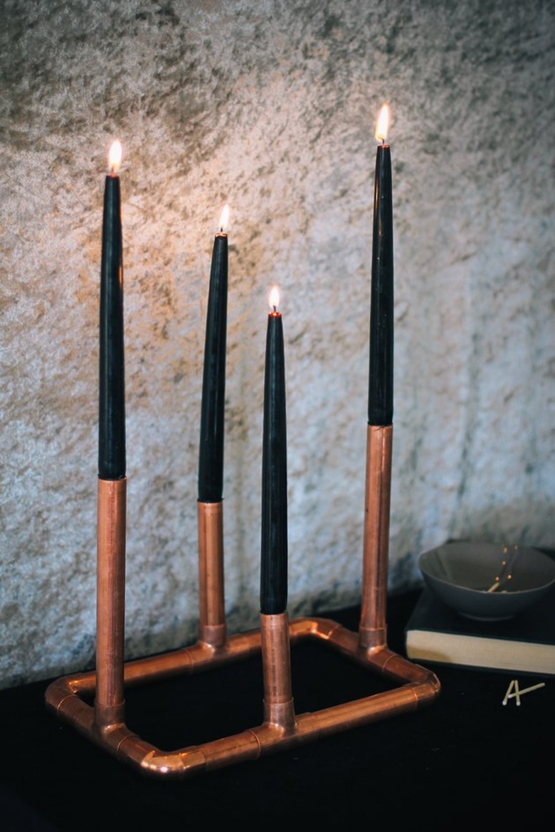 copper candelabra with four black tapered candles