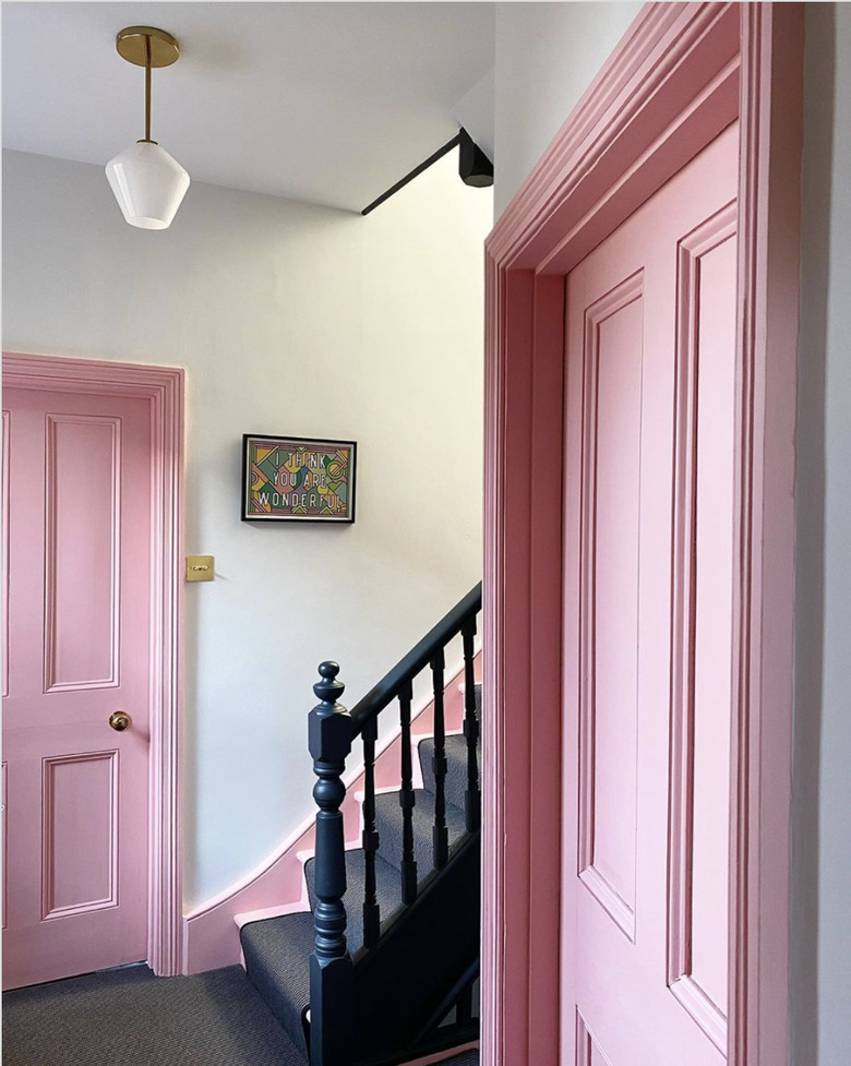 Gray striped stair runners next to pink doors