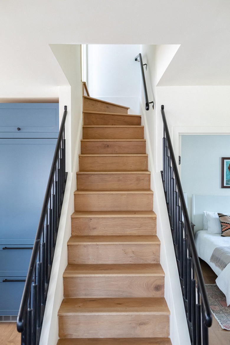 A wood step staircase idea with black banisters