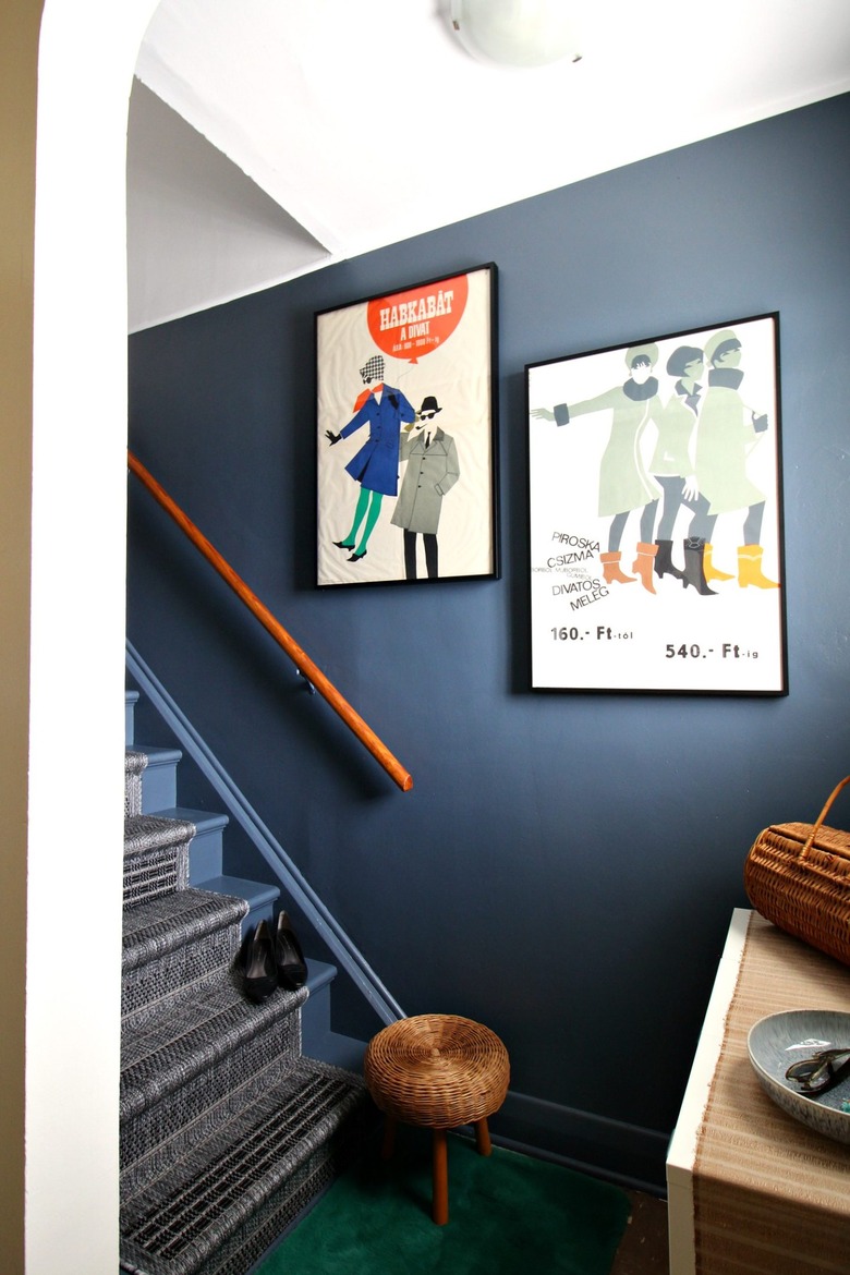 Blue accent wall and vintage posters along stairs