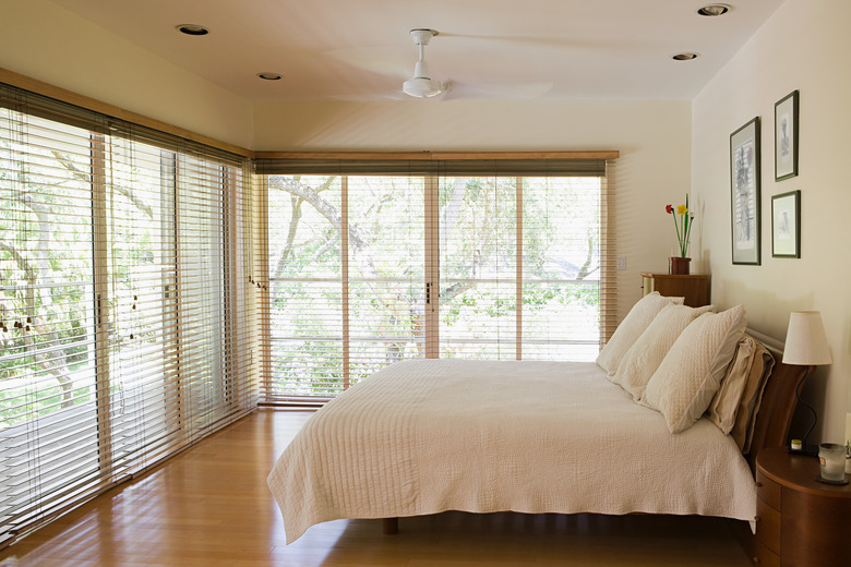 Bedroom with many large, blind-covered windows