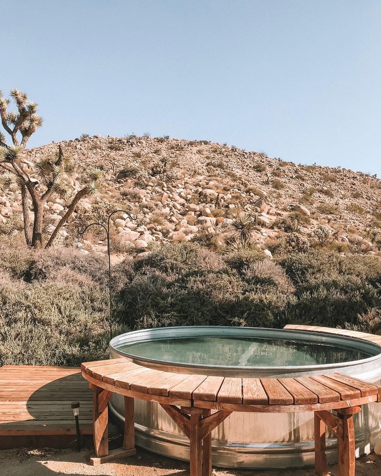 stock tank pool with wood deck with a view of the desert