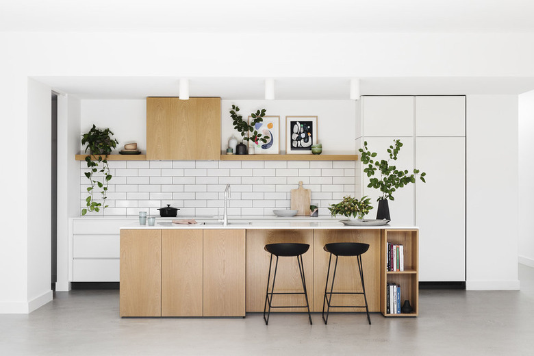 white subway tile kitchen backsplash with wood cabinets and white countertop