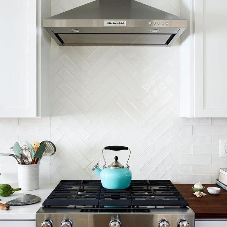 white herringbone pattern subway tile as stove backsplash