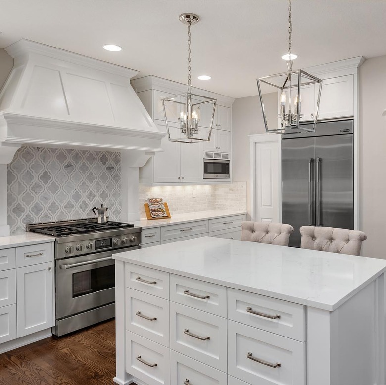 neutral traditional kitchen with arabesque marble backsplash and white countertops