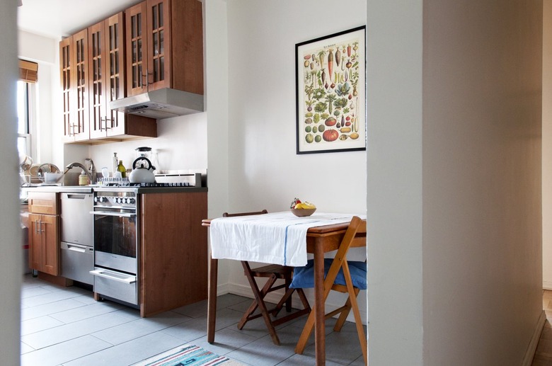 Wooden dining room table in a small kitchen with stove vent