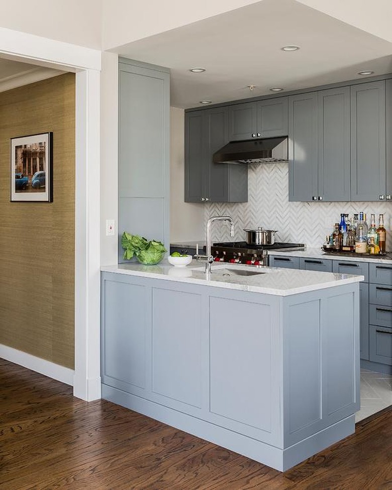 kitchen with light blue cabinets and herringbone backsplash