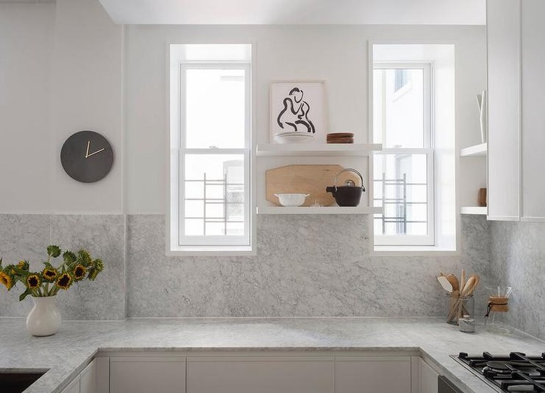 neutral kitchen with marble countertops and backsplash