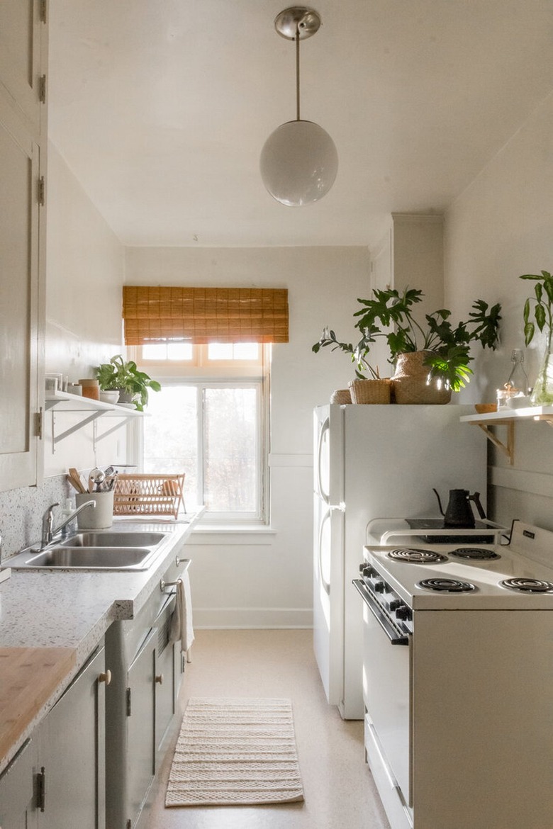 small kitchen with pendant light and two-tone cabinets