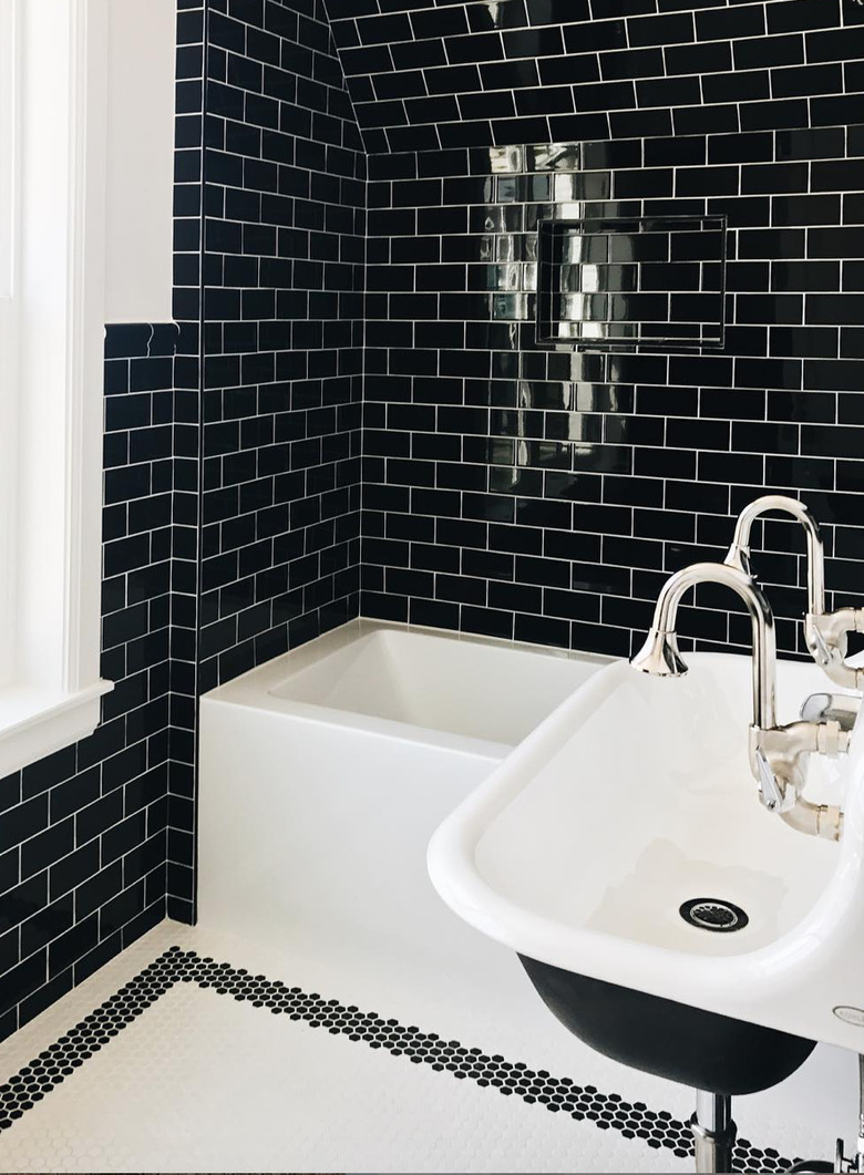 black subway tile in small bathroom with black and white accents