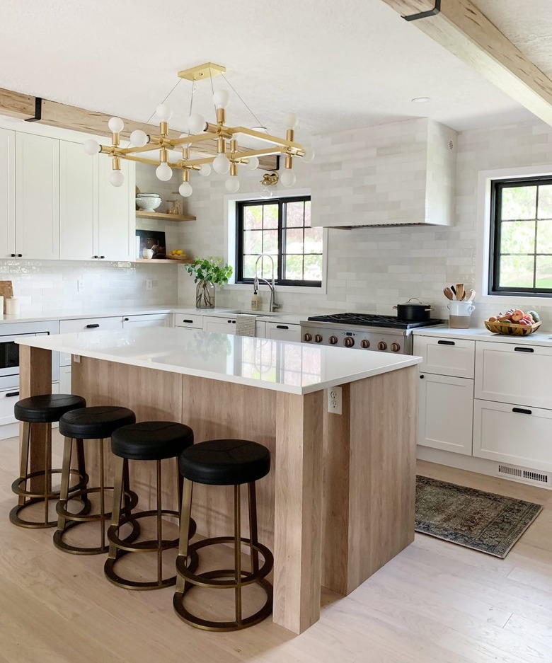 subway tile backsplash with wood island and black barstools