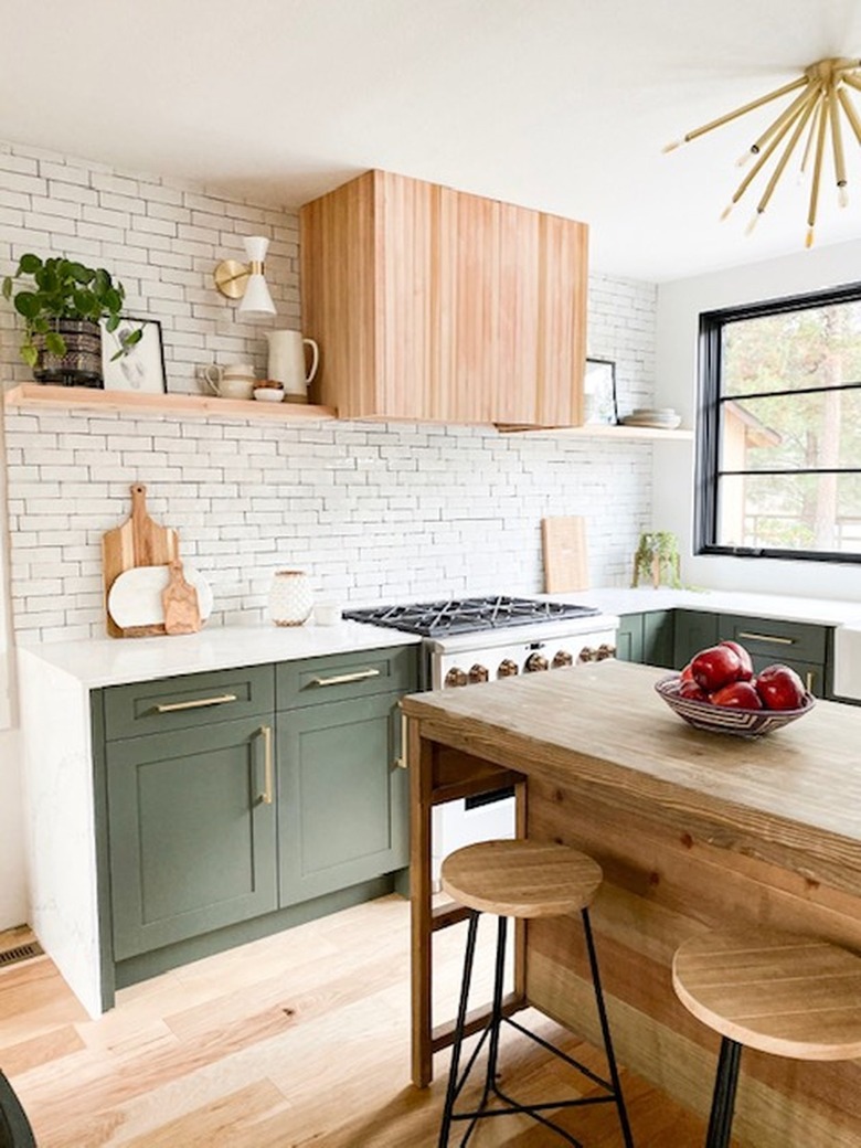 white subway tile backsplash in modern kitchen with green cabinets