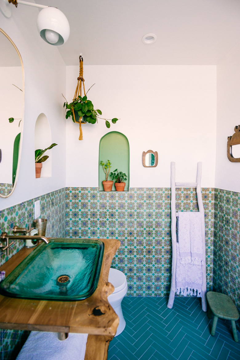 bathroom backsplash idea with green patterned tile wainscoting and chevron tile floor