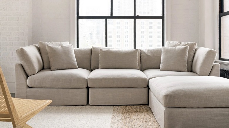 gray sectional with window behind it