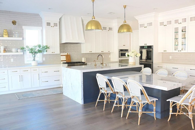 Navy blue and marble T-shaped kitchen island with gold pendant lights