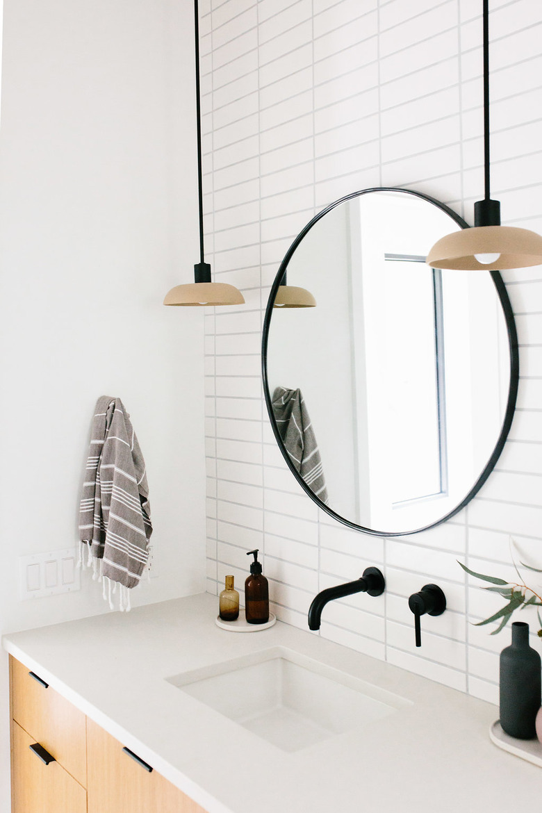 bathroom mirror idea with circle mirror with black frame and white metro tiles in bathroom