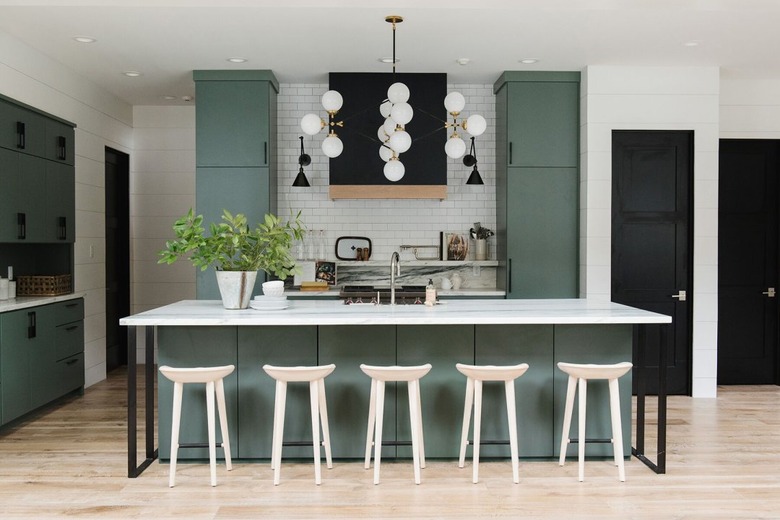 green tall kitchen cabinets in modern design with white countertops