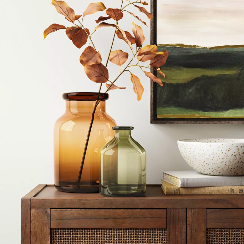 cabinet with glass vases and leaves