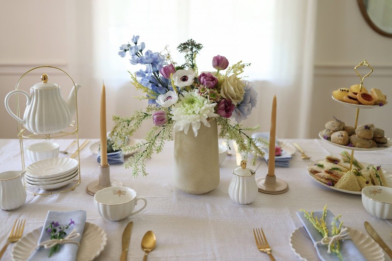 Tea party tablescape with flower centerpiece, tiered serving tray and teapot