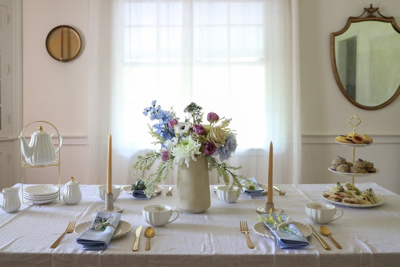 Tea party tablescape with flower centerpiece, tiered serving tray and teapot