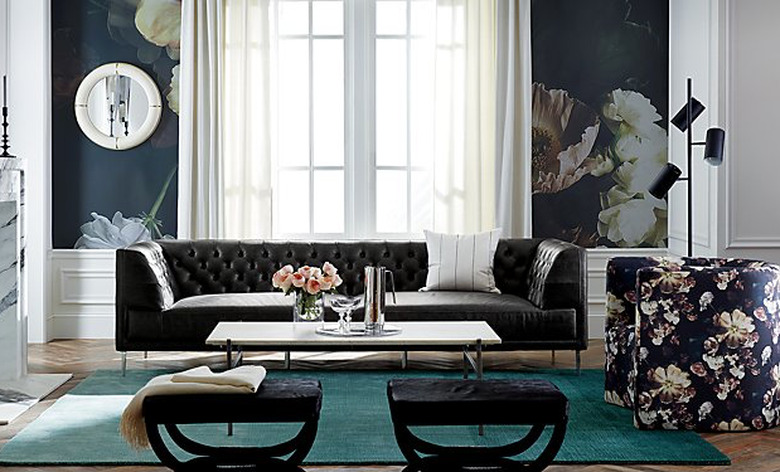 teal color ombre rug in living room with floral wallpaper and tufted sofa