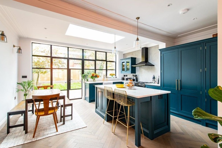 white and teal kitchen island with gold wire bar stools