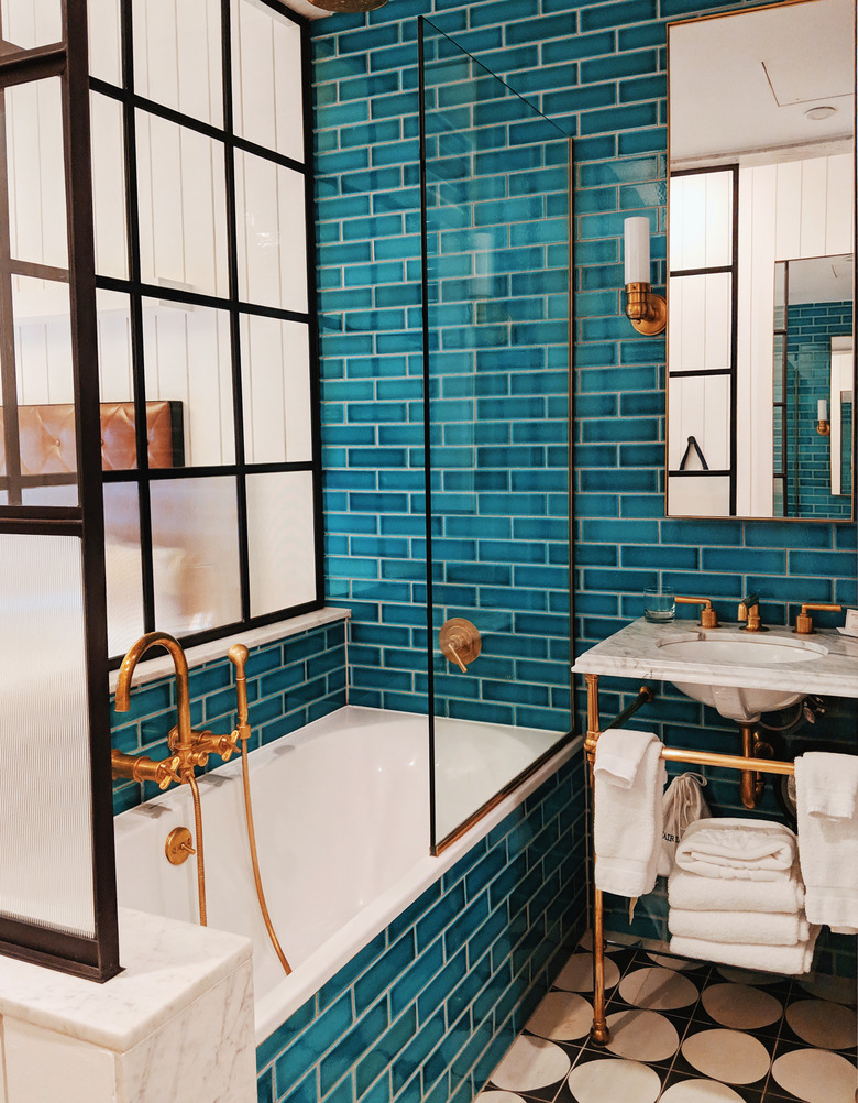 teal shower tile surrounded by iron glass shower doors