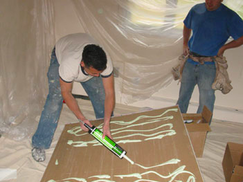 Spreading soundproofing glue.