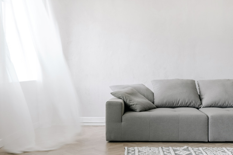 Sofa and sheer curtains in living room.