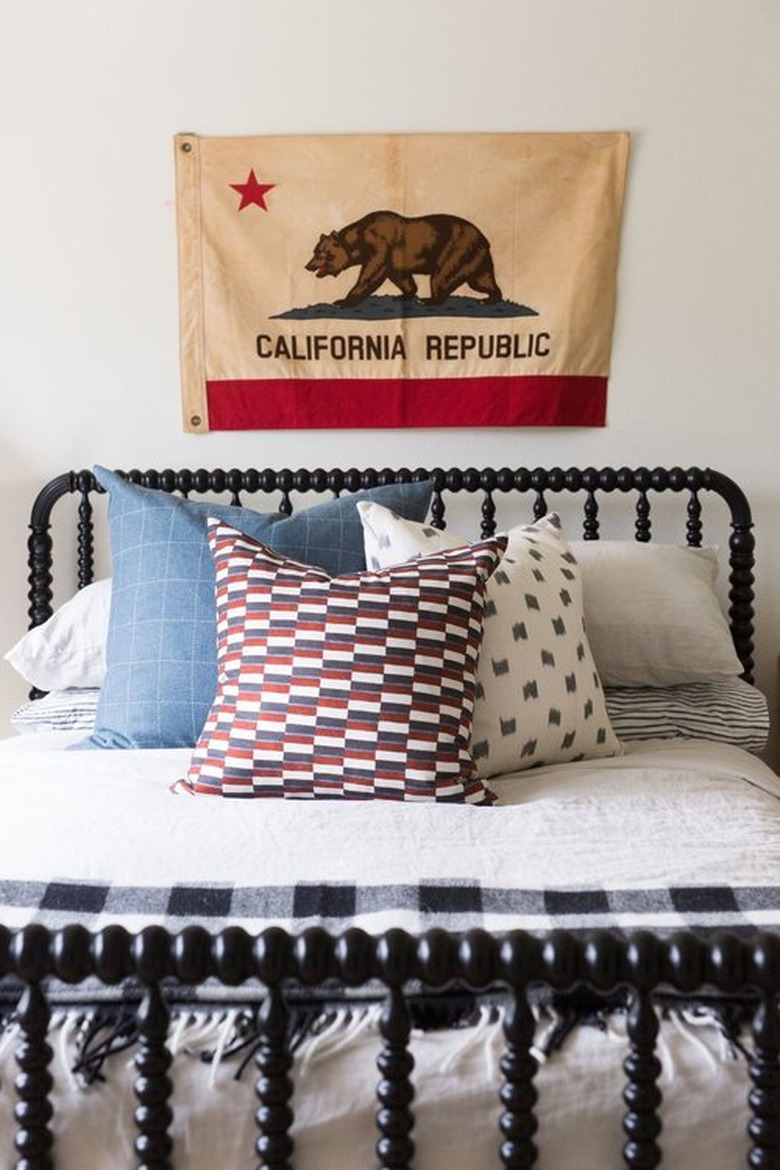 Cali cool teen bedroom idea for girls with vintage flag on wall and black bed frame