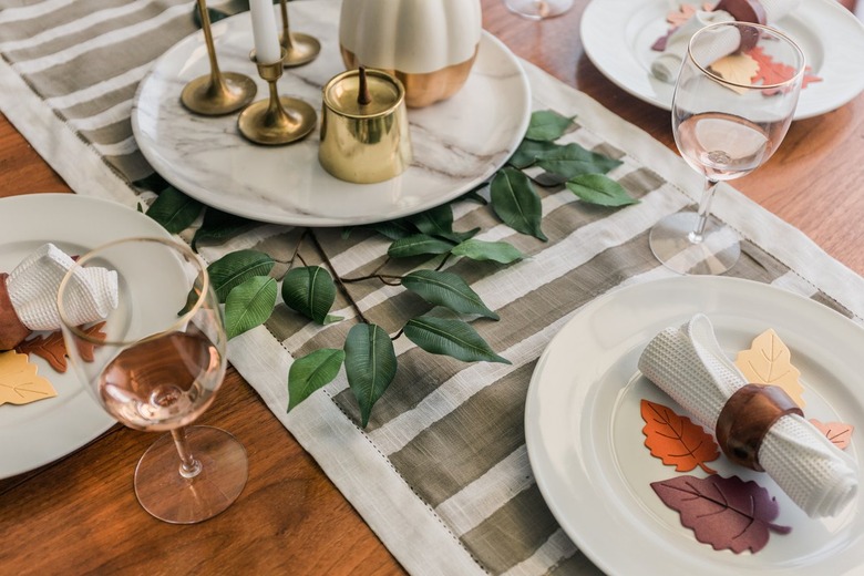 Minimalist striped table runner with plates decorated with paper leaves