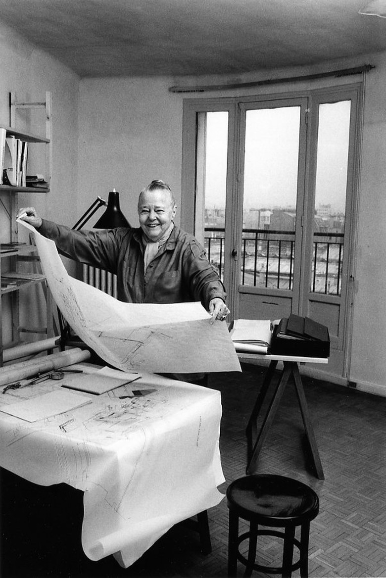 photograph of Charlotte Perriand holding a large sheet of paper